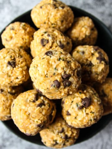 A black dish filled with ball-shaped oatmeal bites.