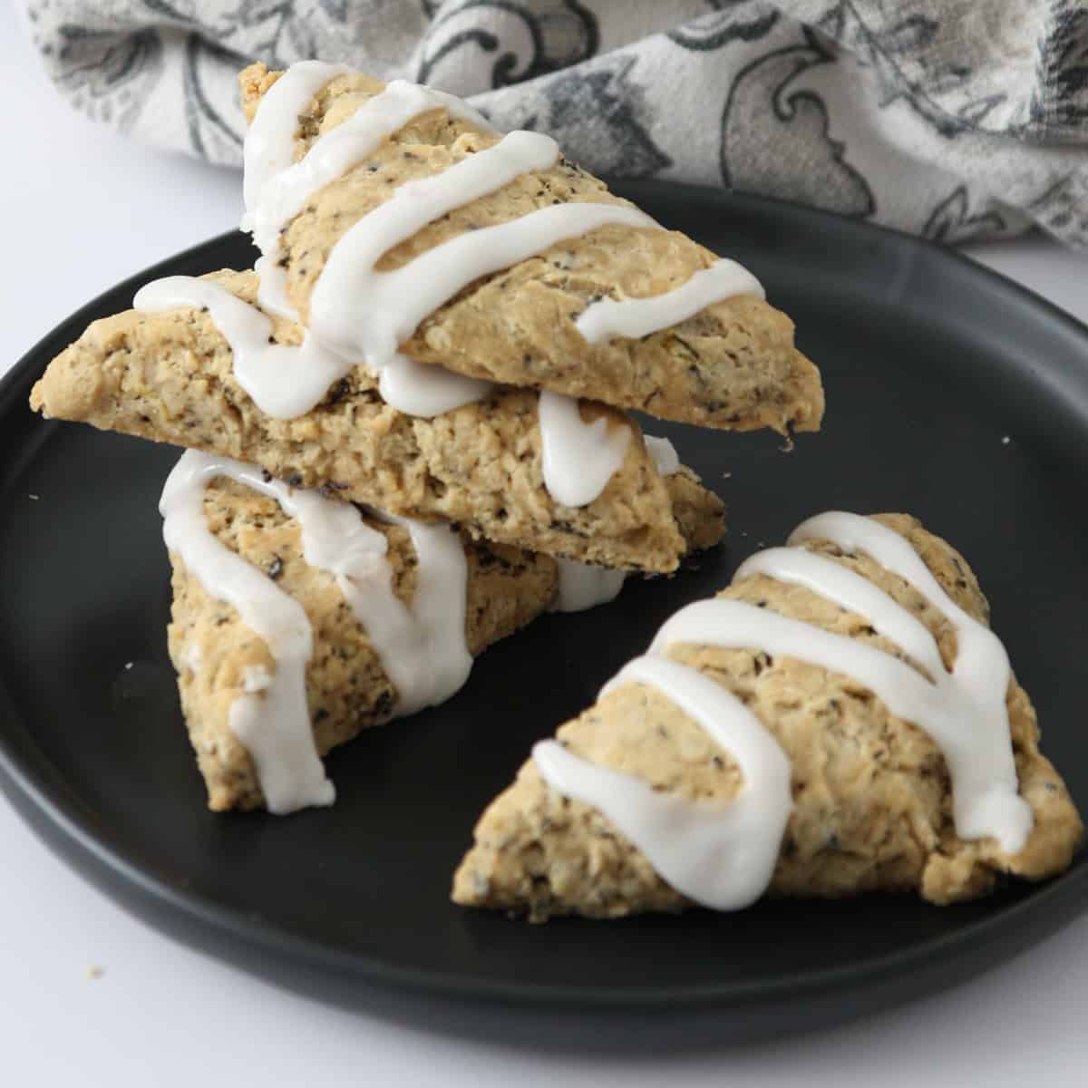 A stack of three Earl Grey scones on a black plate.