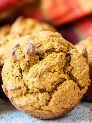 An oat flour pumpkin muffin on a marble countertop.